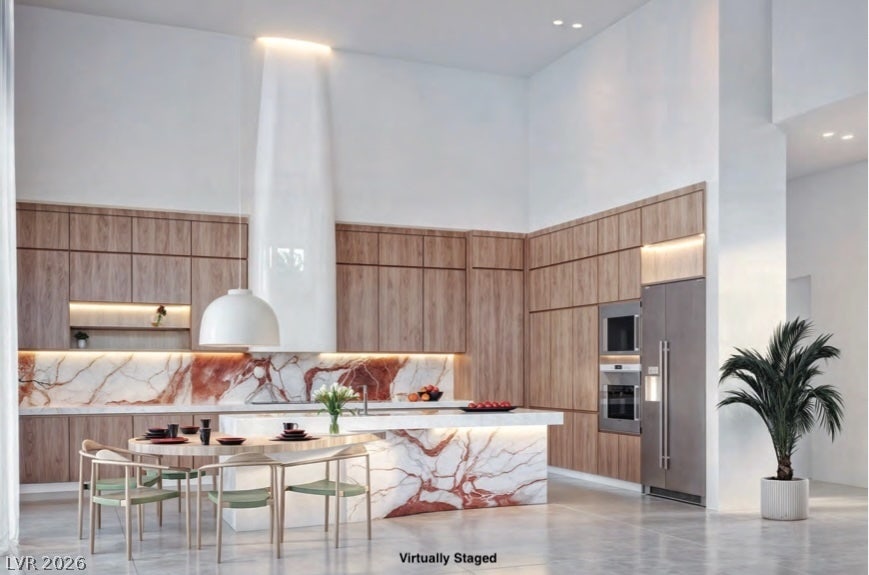 "Virtually Staged" Dramatic high ceilings and matching marble finishes define this modern culinary space.