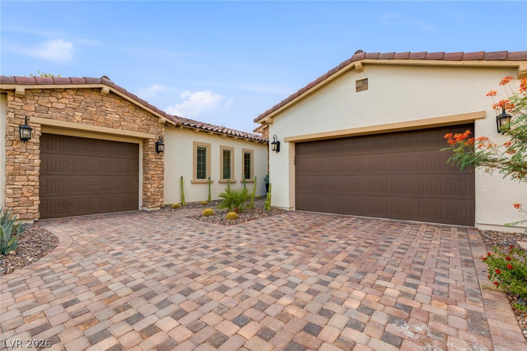 4078 San Franchesca Court, Las Vegas, NV 89141 A paver driveway leads to two garages, showcasing attractive stone and stucco accents with tasteful desert landscaping.