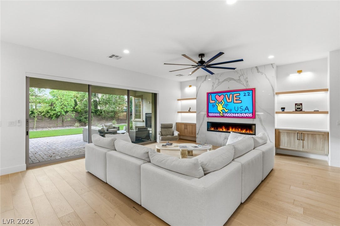4078 San Franchesca Court, Las Vegas, NV 89141 A spacious living room with a linear fireplace and direct access to an outdoor patio.