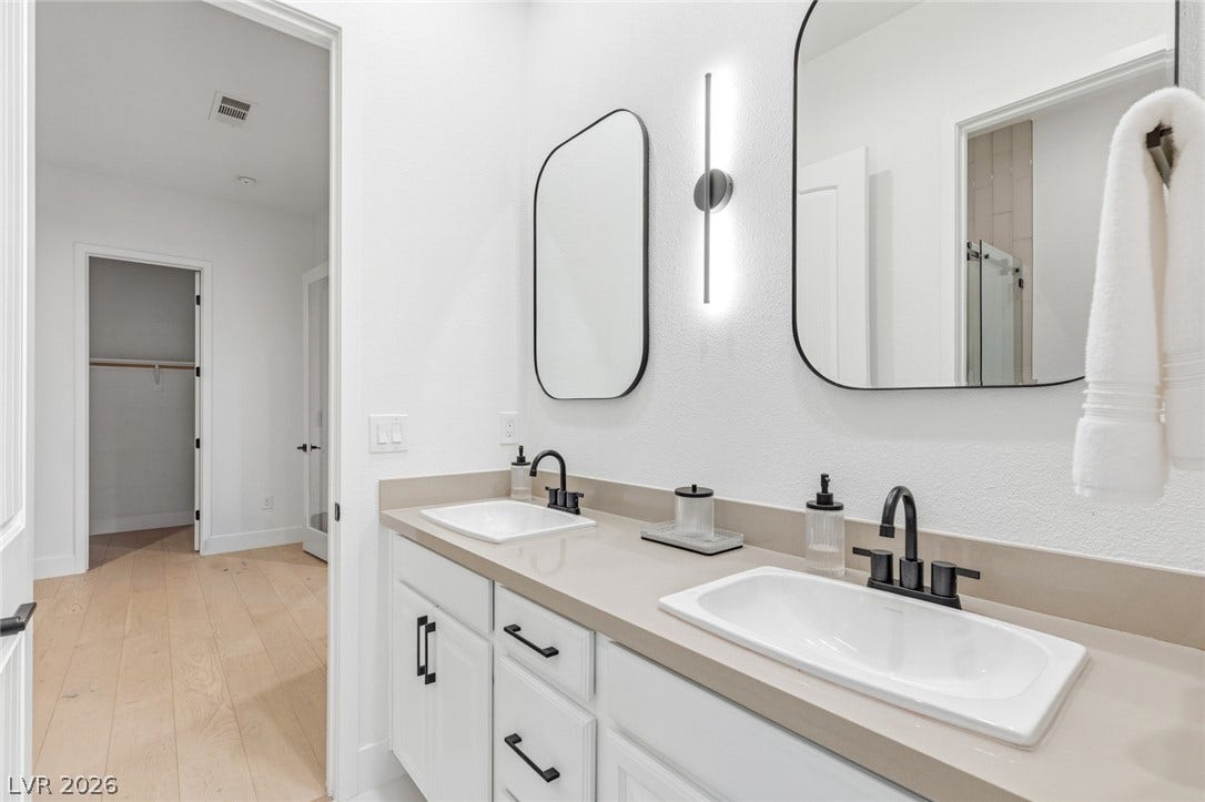 4078 San Franchesca Court, Las Vegas, NV 89141 Double vanities with matte black fixtures and mirrors enhance this well-appointed bathroom.