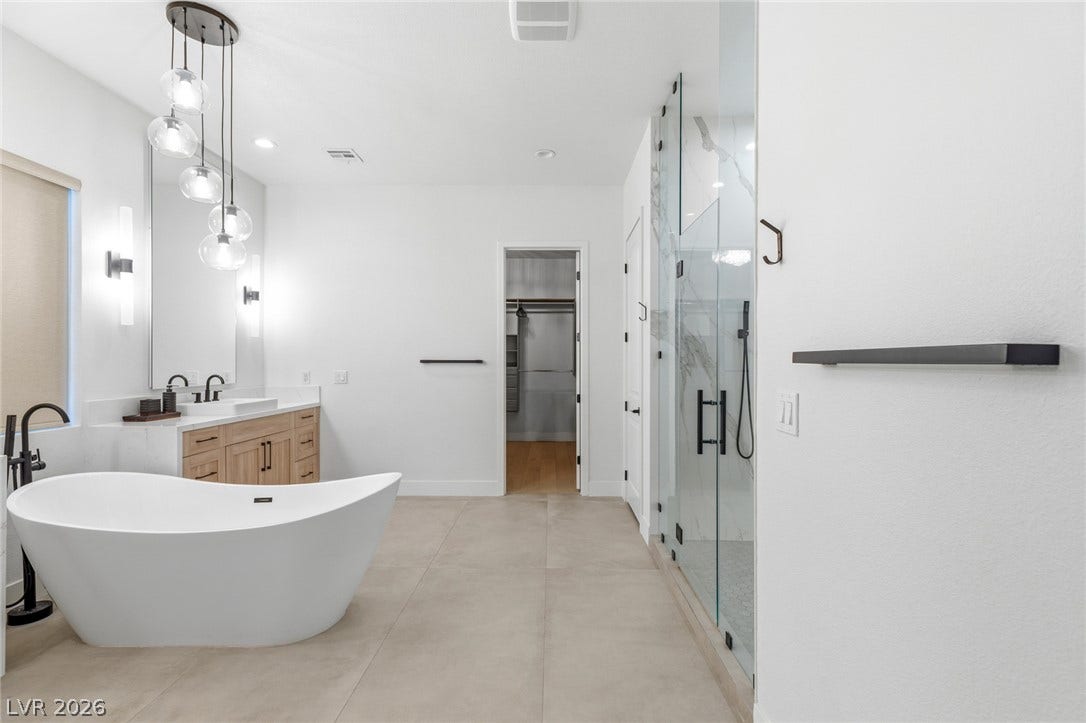 4078 San Franchesca Court, Las Vegas, NV 89141 A well-lit primary bathroom features a standalone soaking tub and a spacious walk-in shower.