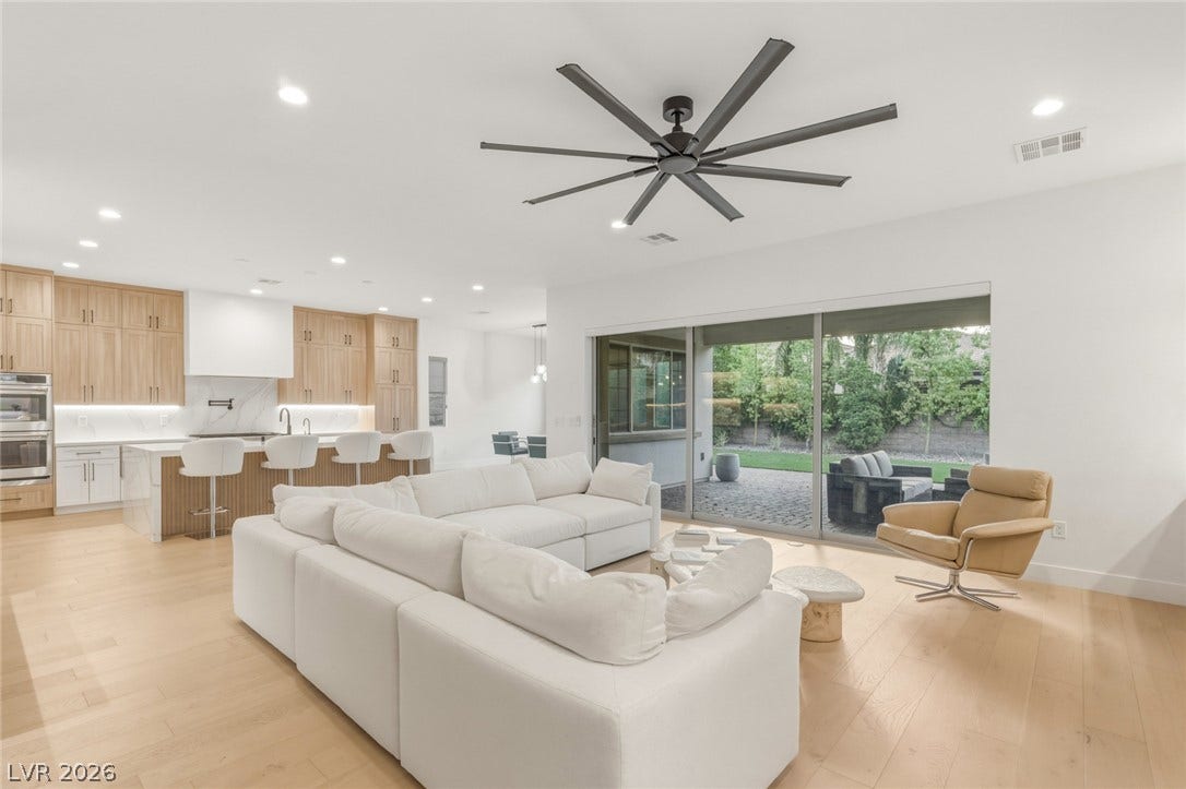 4078 San Franchesca Court, Las Vegas, NV 89141 An open-concept living space with a gourmet kitchen, hardwood flooring, and sliding glass doors that lead to a private patio.