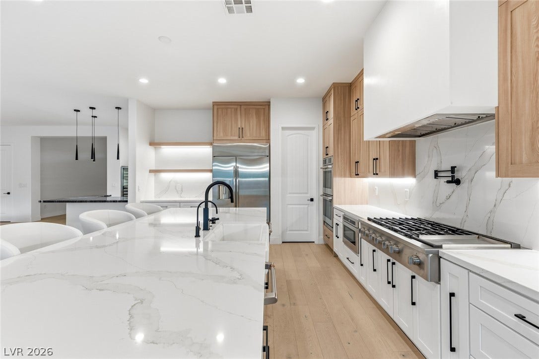 4078 San Franchesca Court, Las Vegas, NV 89141 Culinary excellence awaits in this well-appointed kitchen, featuring a spacious island with a sink and a professional-grade range.