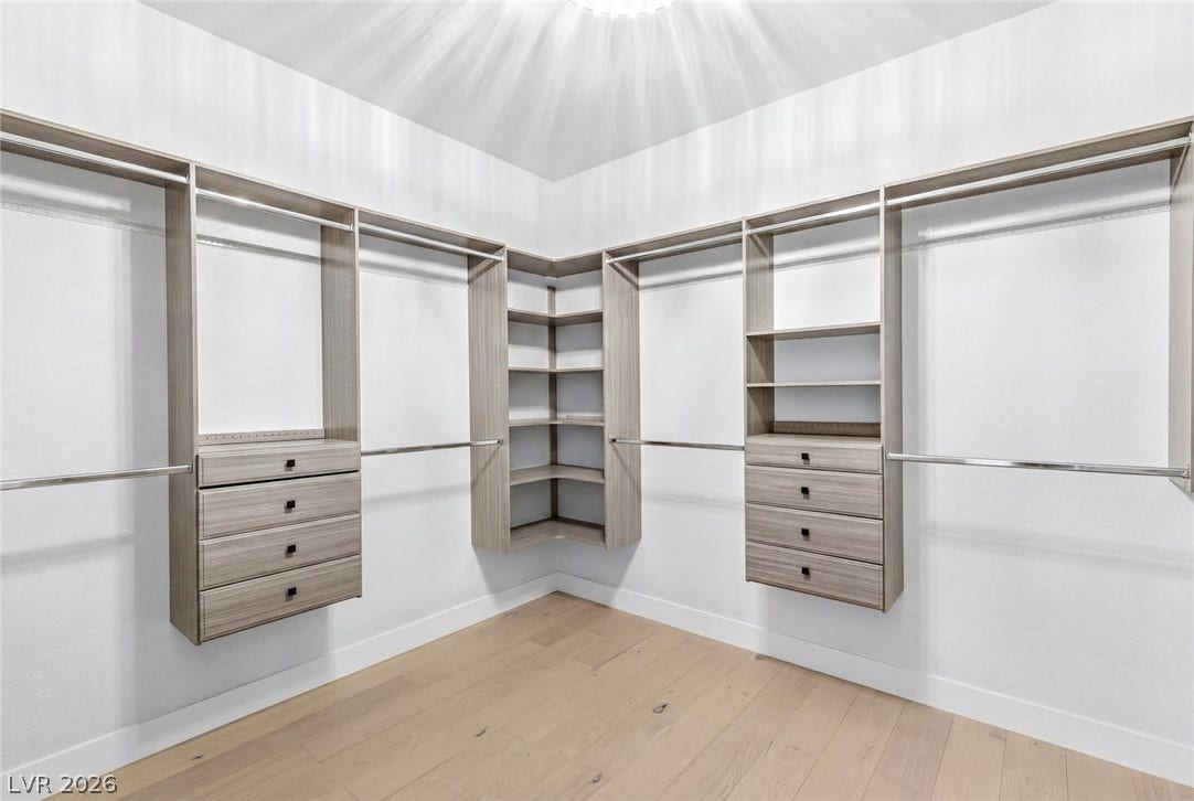 4078 San Franchesca Court, Las Vegas, NV 89141 Customizable closet systems with ample storage and sleek wood flooring create a functional and orderly dressing space.