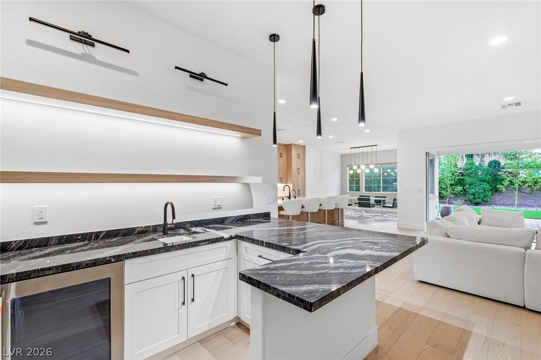 4078 San Franchesca Court, Las Vegas, NV 89141 An open-concept living space with a contemporary wet bar, kitchen island, and inviting outdoor access.