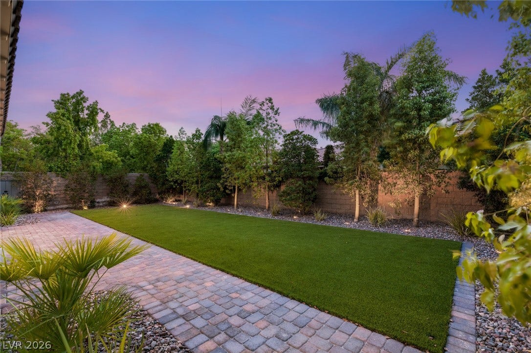 4078 San Franchesca Court, Las Vegas, NV 89141 An inviting backyard oasis offers a lush lawn and paver patio, perfect for evening gatherings.