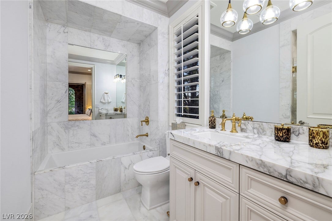 4 Ayden Drive, Henderson, NV 89052 Elegance defines this space lined with classic marble tile, custom cabinetry, and premium fixtures.
