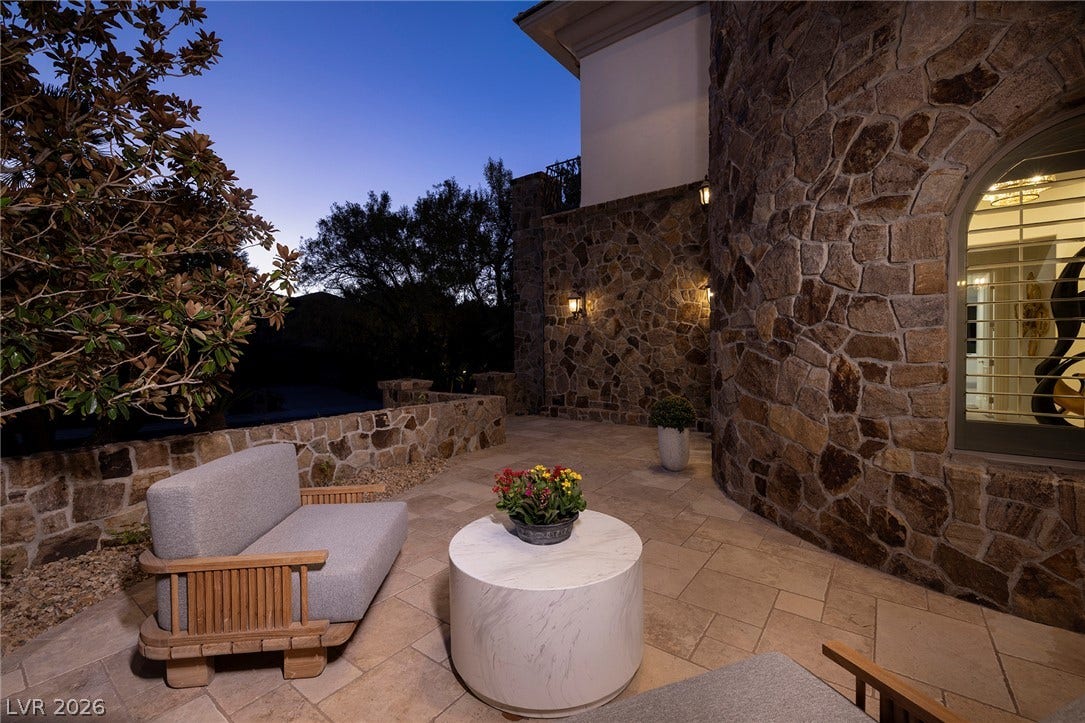 4 Ayden Drive, Henderson, NV 89052 Natural stone walls and stone tile flooring define this elegant outdoor patio space.