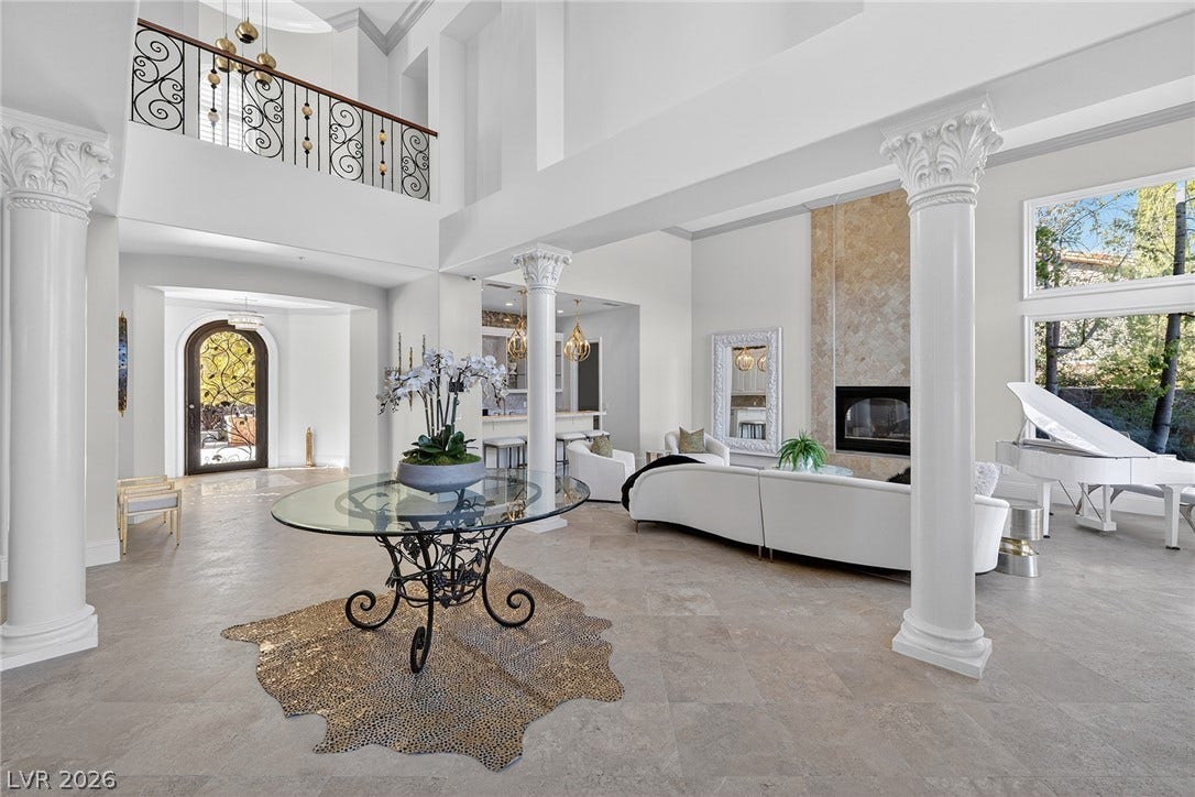 4 Ayden Drive, Henderson, NV 89052 Towering columns and a dramatic fireplace define this double-height entry hall.