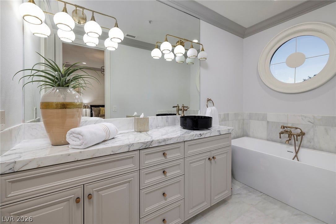 4 Ayden Drive, Henderson, NV 89052 Marble finishes and a unique round window elevate this elegant bathroom design.