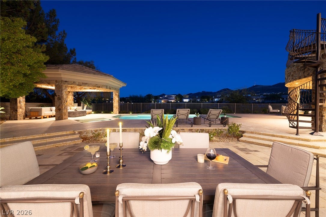 4 Ayden Drive, Henderson, NV 89052 An inviting outdoor terrace offers views of the surrounding hills and pool at twilight.
