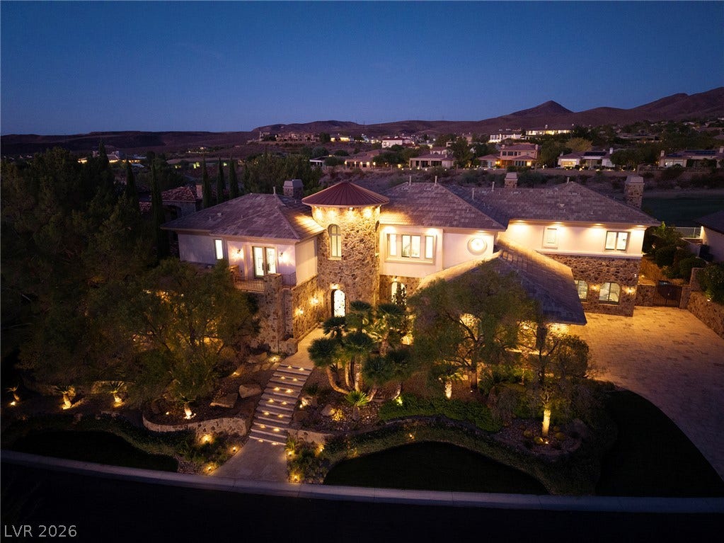 4 Ayden Drive, Henderson, NV 89052 Dramatic night illumination highlights the stone masonry, turret entryway, and multi-level roofline of this estate.