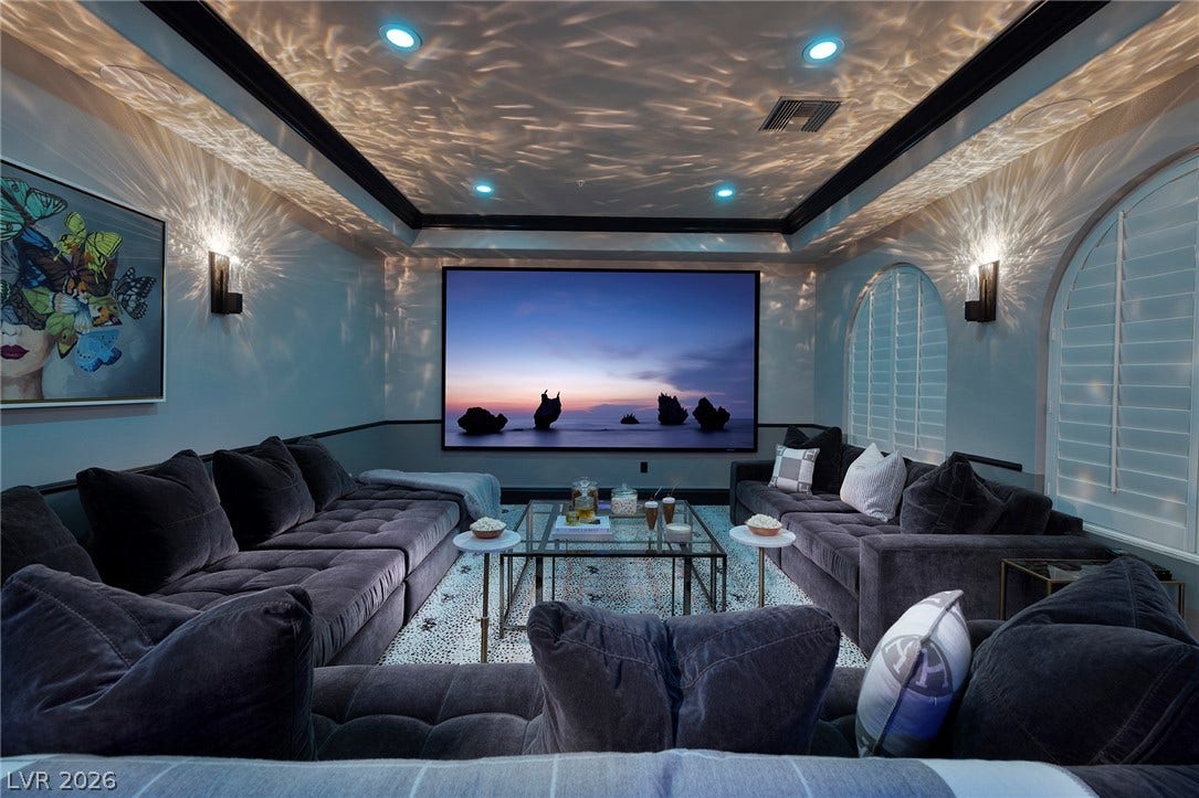 4 Ayden Drive, Henderson, NV 89052 Custom lighting effects and built-in projection create a dedicated theater atmosphere under a tray ceiling.