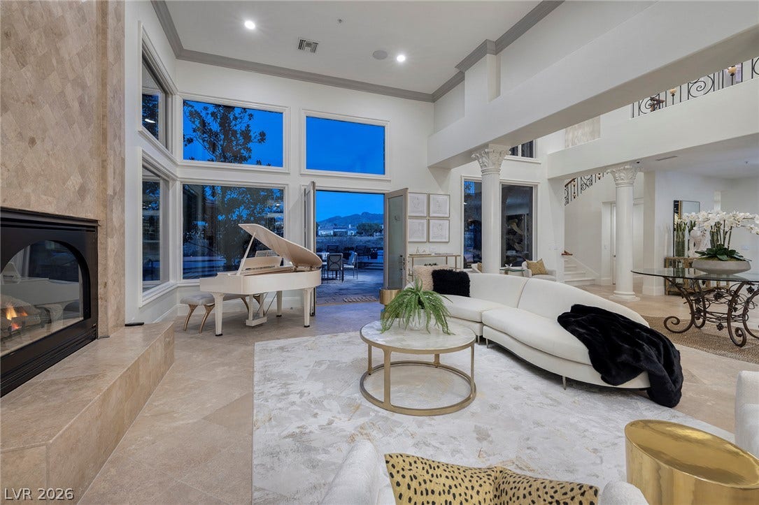 4 Ayden Drive, Henderson, NV 89052 Grand arched fireplace and towering window walls anchor this soaring formal living area.