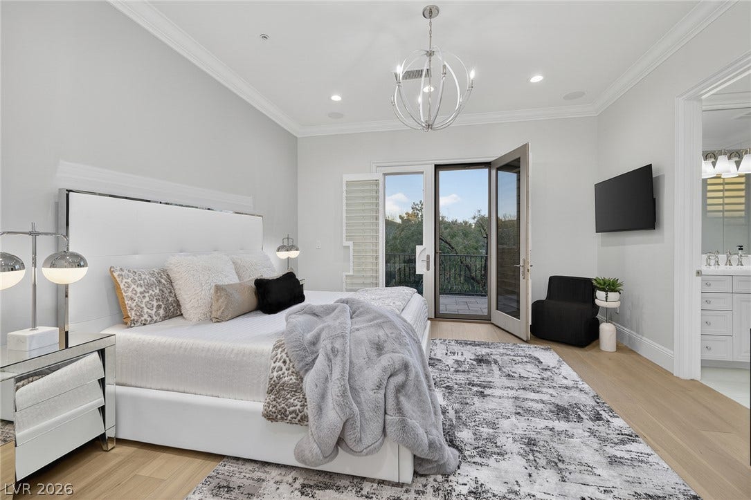 4 Ayden Drive, Henderson, NV 89052 Elegant crown molding and classic hardwood floors elevate this airy primary bedroom retreat.