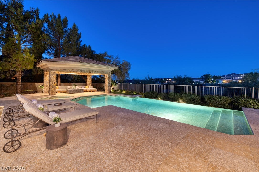 4 Ayden Drive, Henderson, NV 89052 A spacious stone patio surrounds a sparkling swimming pool adjacent to a covered pavilion.