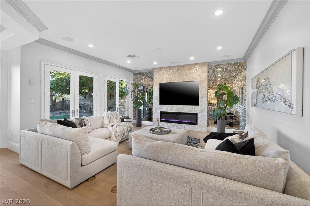 4 Ayden Drive, Henderson, NV 89052 Recessed lighting, crown molding, and hardwood flooring frame a modern linear fireplace.