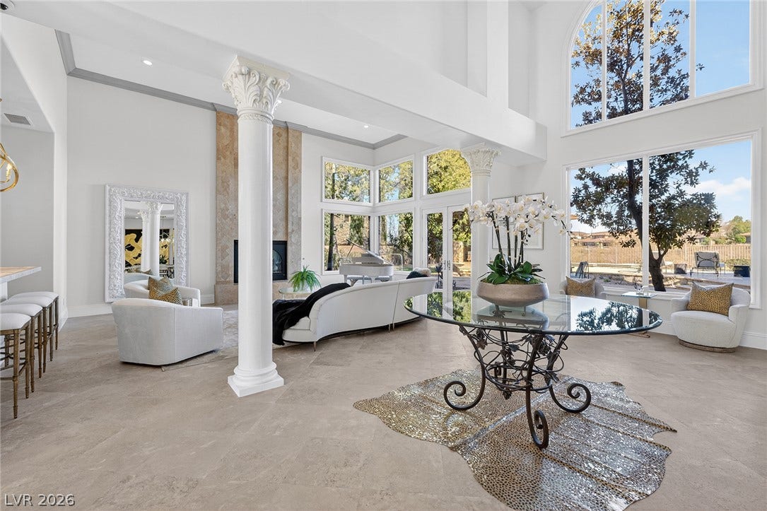 4 Ayden Drive, Henderson, NV 89052 Towering windows and stone tile flooring define this grand, light-filled living space with architectural columns.