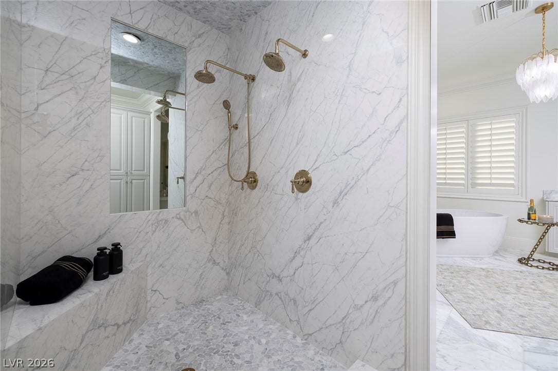 4 Ayden Drive, Henderson, NV 89052 Veined stone tiles and gold fixtures create an elegant walk-in shower experience.