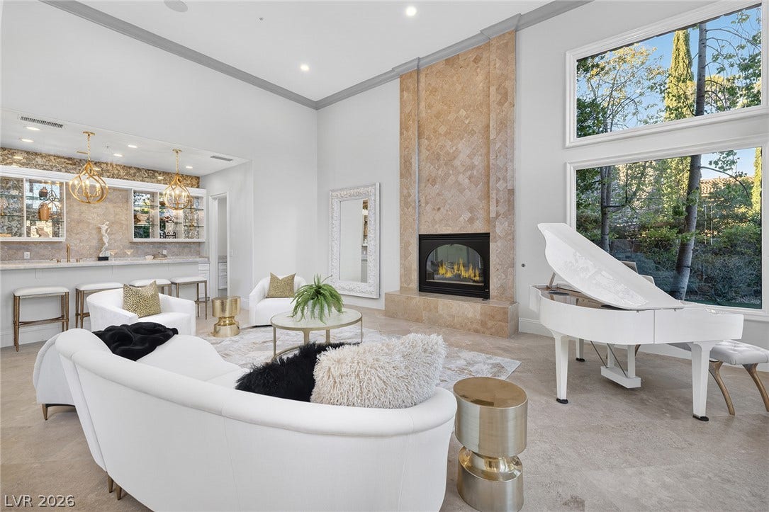 4 Ayden Drive, Henderson, NV 89052 Soaring ceilings and a floor-to-ceiling stone fireplace anchors this light-filled living space.