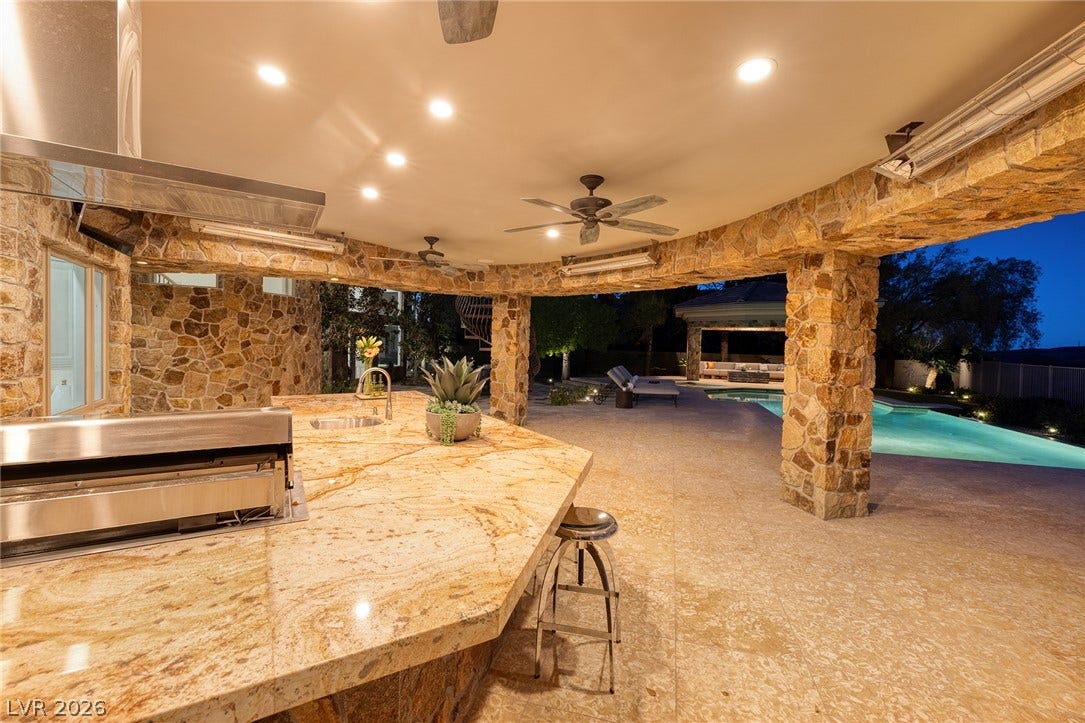 4 Ayden Drive, Henderson, NV 89052 An expansive covered patio features premium stone finishes and overlooks the resort-style pool.