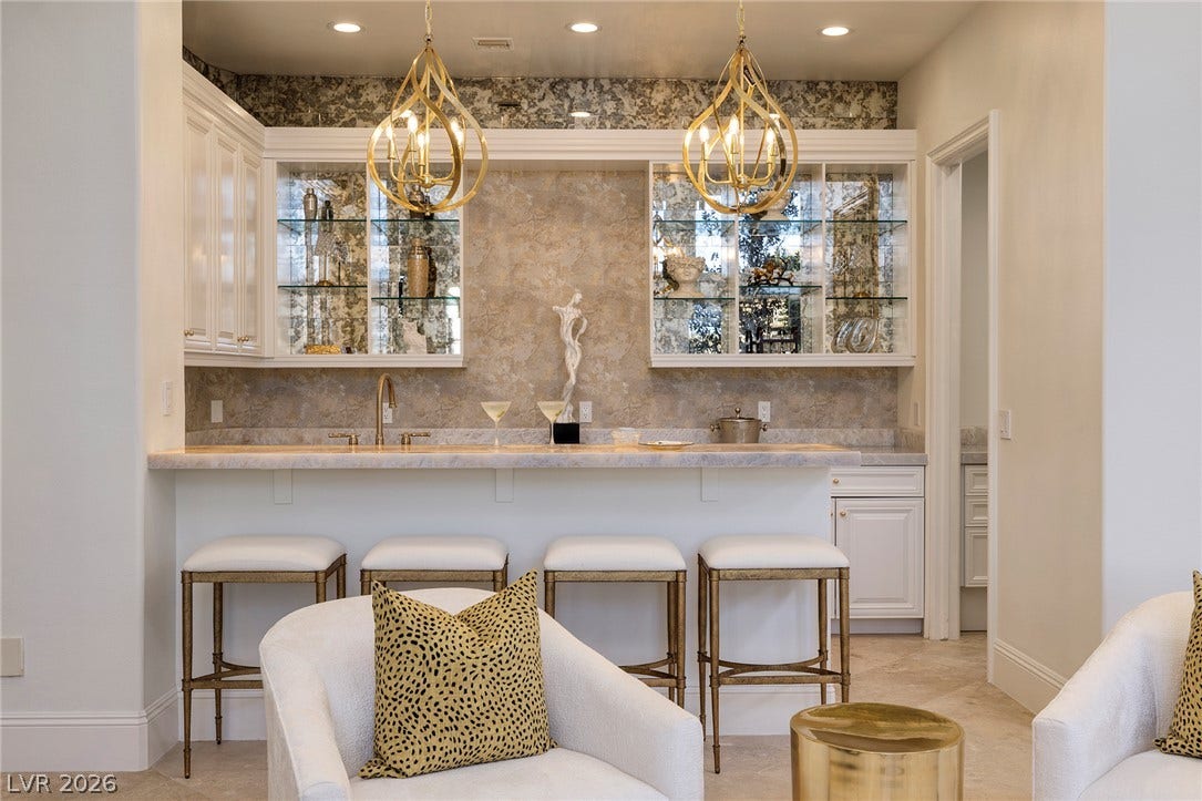 4 Ayden Drive, Henderson, NV 89052 A well-equipped home bar features elegant stone counters and customized cabinetry under recessed lighting.