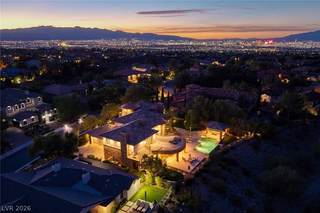4 Ayden Drive, Henderson, NV 89052 Glittering city lights and majestic mountain ranges create a breathtaking backdrop at twilight.