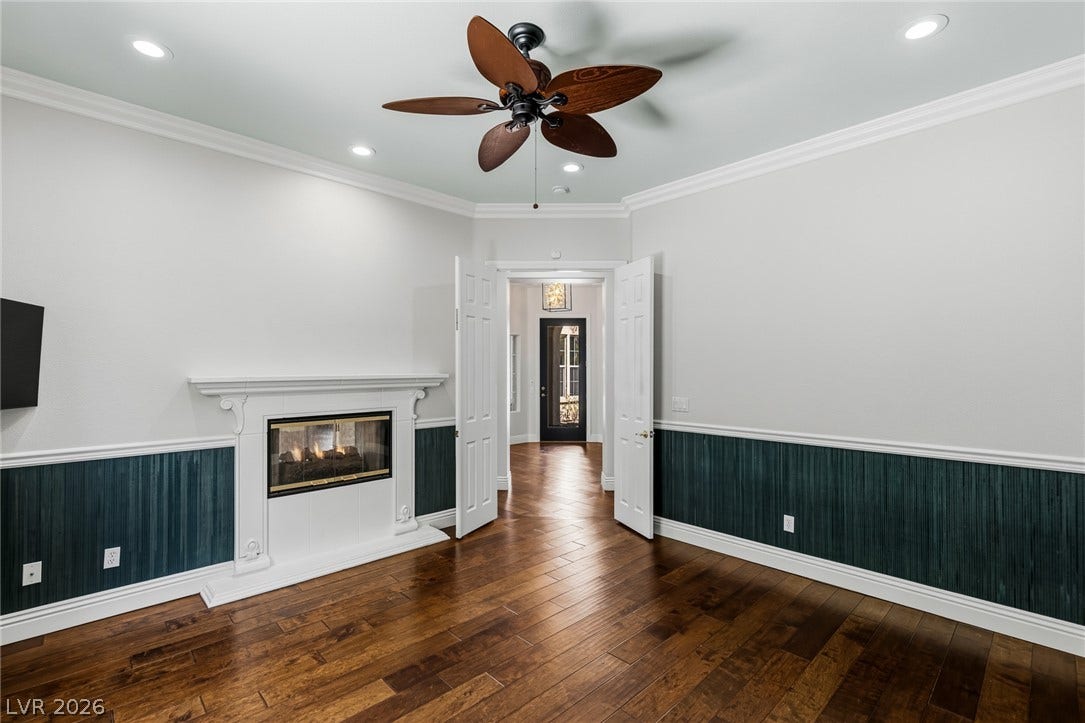 1201 Mersault Court, Las Vegas, NV 89144 Rich hardwood floors and elegant wainscoting frame a classic fireplace in this refined space.