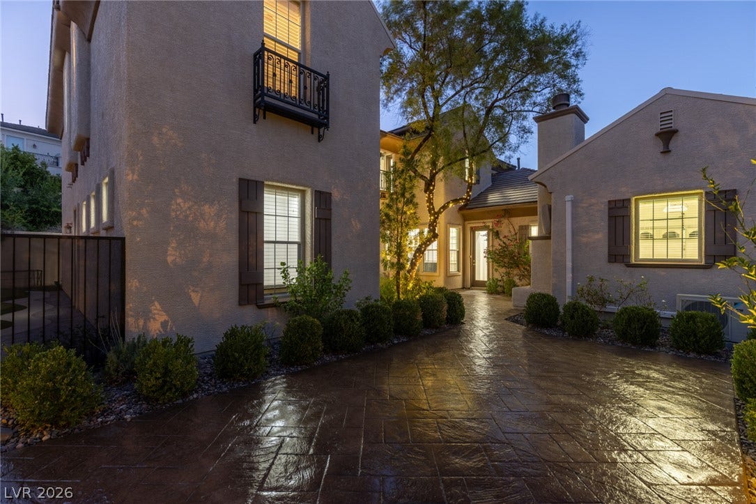 1201 Mersault Court, Las Vegas, NV 89144 A spacious stamped concrete driveway leads toward the stucco exterior of this multi-level home.