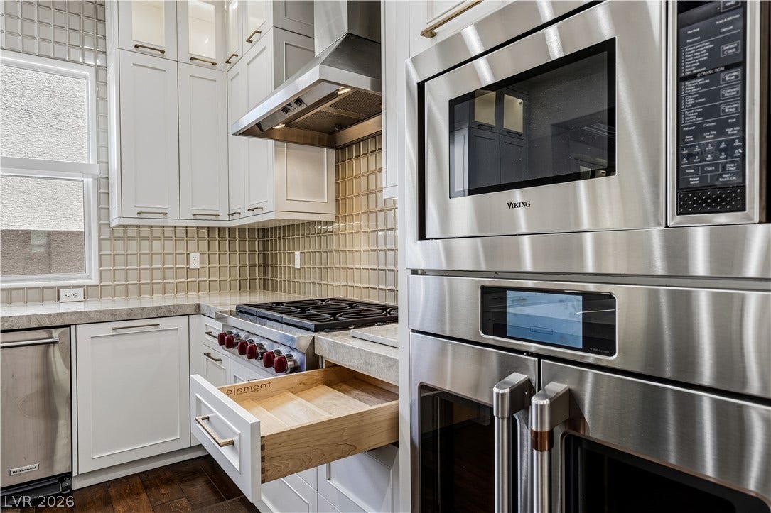 1201 Mersault Court, Las Vegas, NV 89144 Gleaming stainless steel appliances integrate seamlessly alongside crisp cabinetry and textured tile backsplashes.