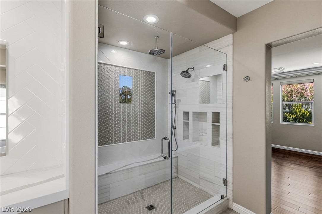 1201 Mersault Court, Las Vegas, NV 89144 Elegant tile details and a glass enclosure define this modern walk-in shower.