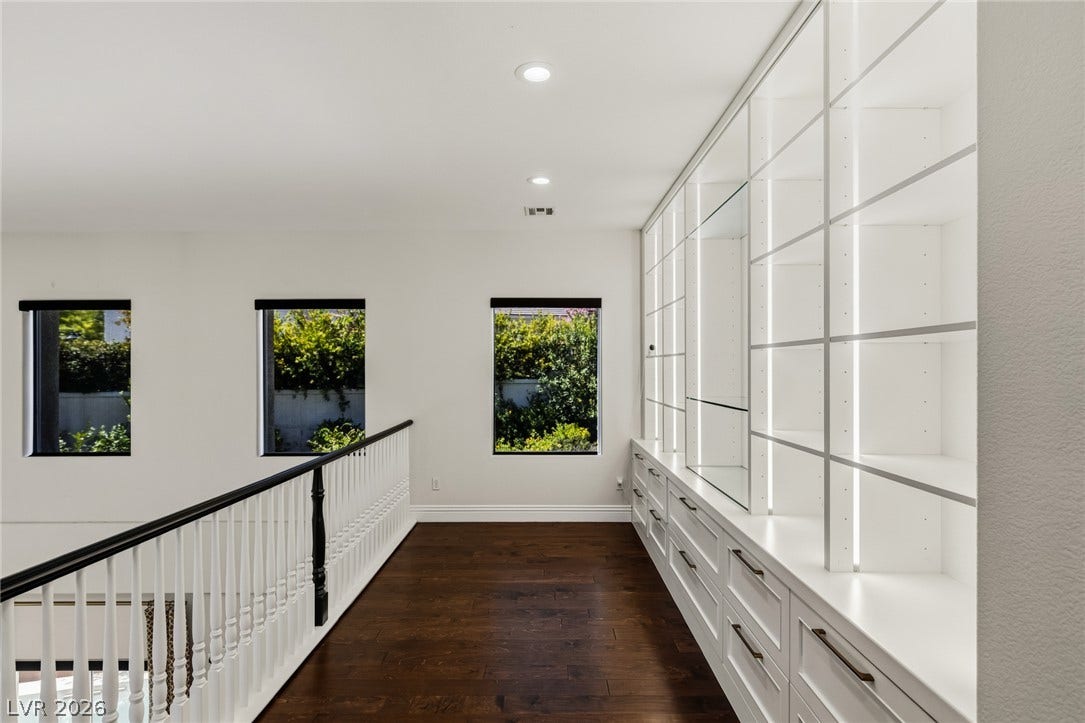 1201 Mersault Court, Las Vegas, NV 89144 Rich hardwood floors complement the custom floor-to-ceiling built-ins along this upper-level hallway.