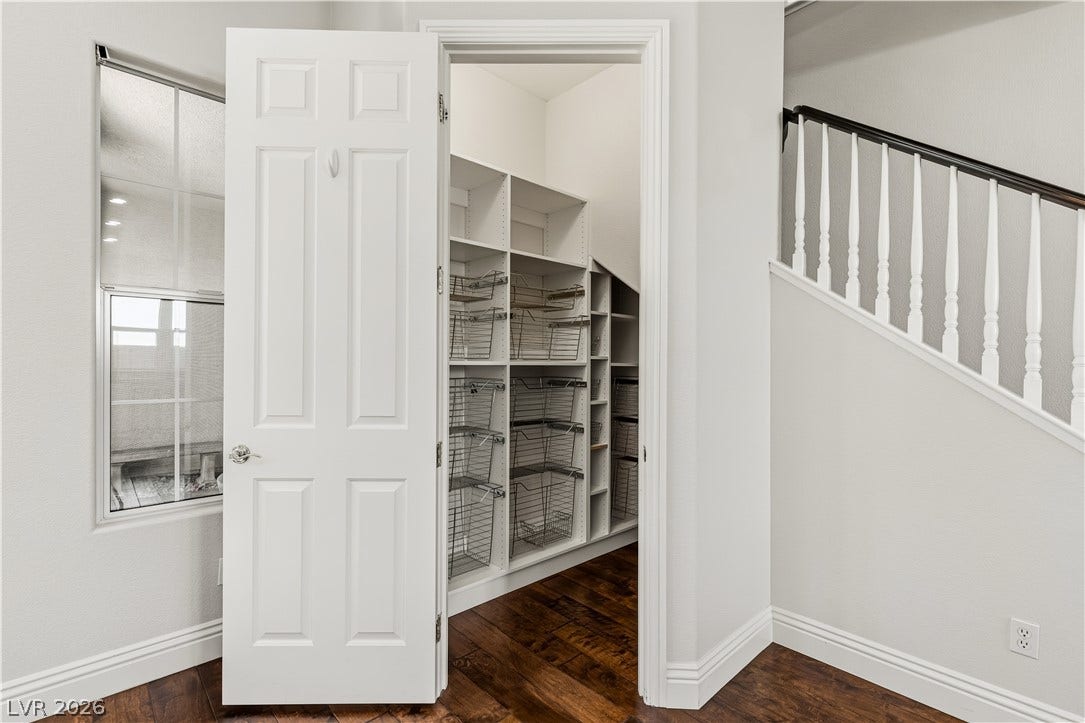 1201 Mersault Court, Las Vegas, NV 89144 Rich hardwood flooring anchors the entry to a structured storage pantry under the staircase.