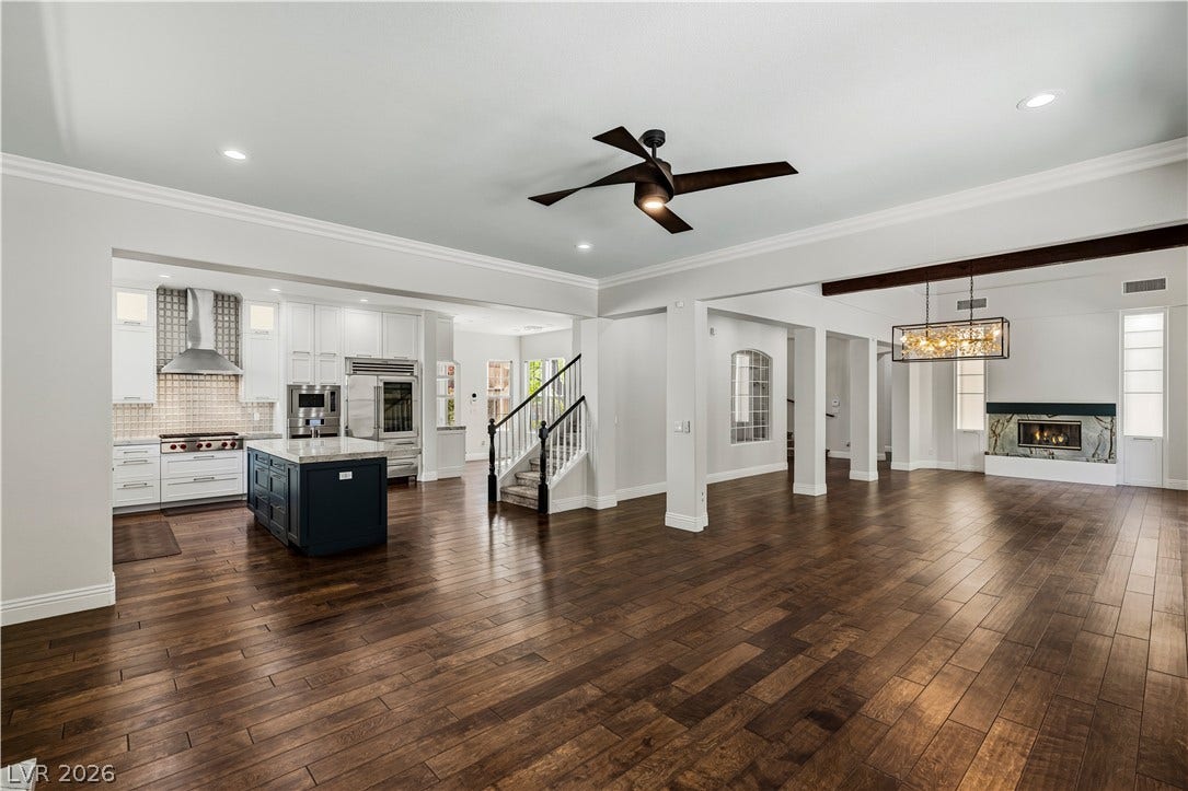 1201 Mersault Court, Las Vegas, NV 89144 Gleaming hardwood floors run through a spacious open layout connecting the kitchen and living areas.
