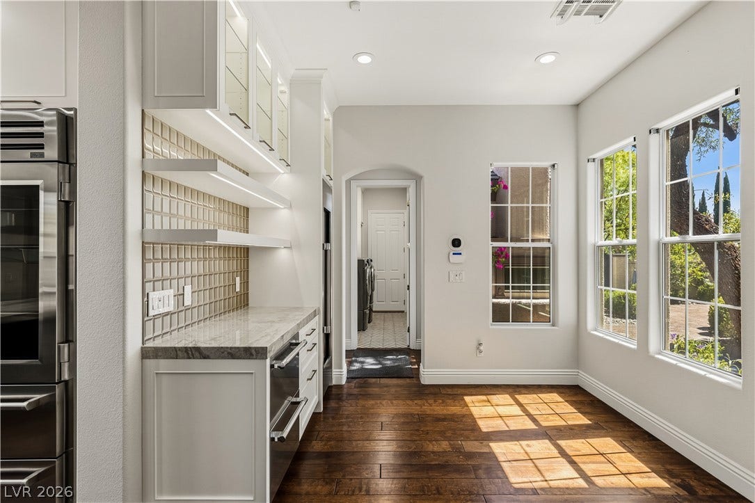 1201 Mersault Court, Las Vegas, NV 89144 Rich hardwood floors and abundant natural light highlight this versatile kitchen transitions area.