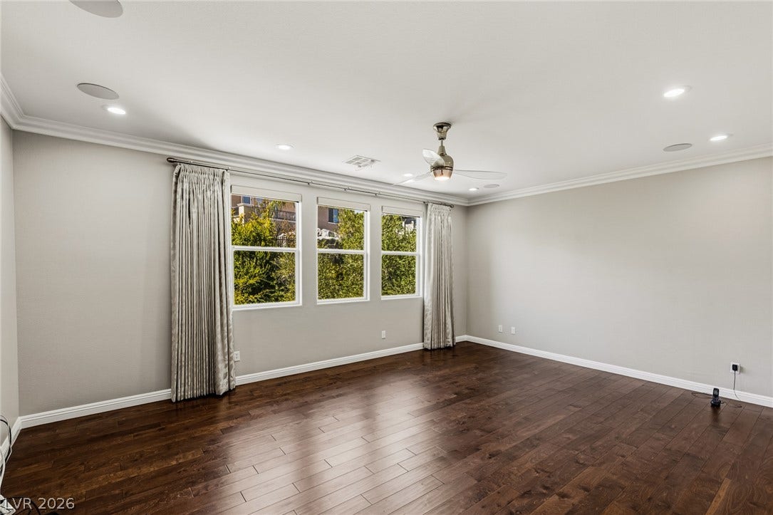 1201 Mersault Court, Las Vegas, NV 89144 Rich hardwood floors anchor this light-filled room framed by classic crown molding and tall windows.