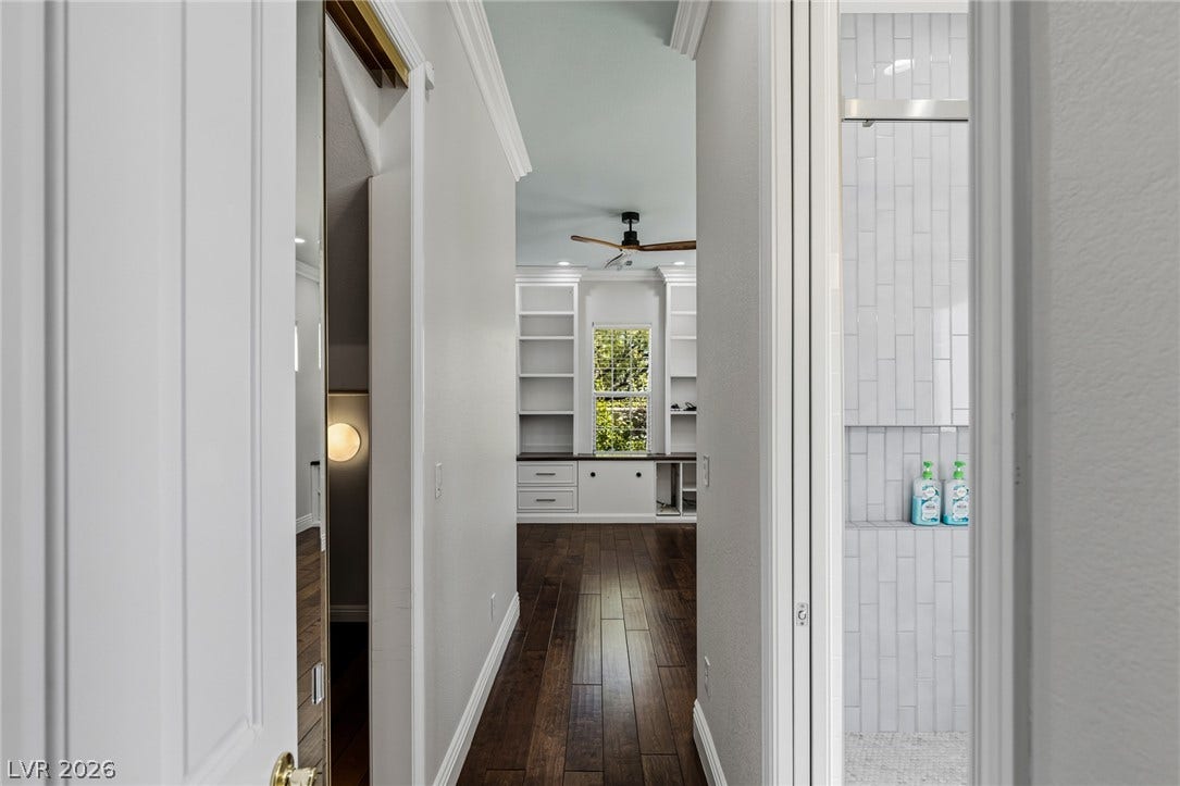 1201 Mersault Court, Las Vegas, NV 89144 Rich hardwood floors lead past a tiled shower toward custom built-in shelving.