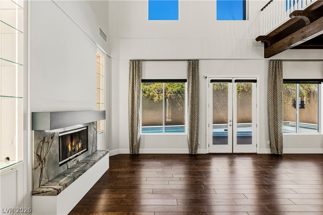 1201 Mersault Court, Las Vegas, NV 89144 Formal Living Room. Gleaming hardwood floors and a modern fireplace elevate this double-height living space.