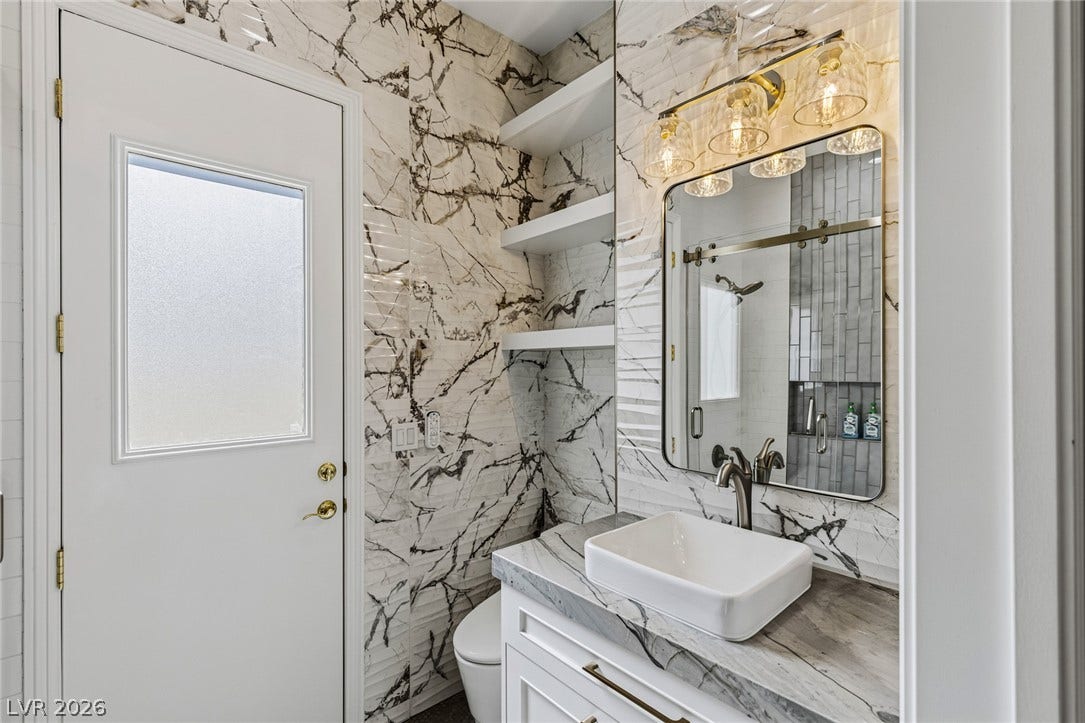 1201 Mersault Court, Las Vegas, NV 89144 Striking marble-patterned wall tile pairs beautifully with a modern vanity and clean white finishes.