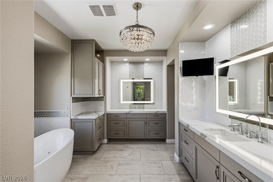 1201 Mersault Court, Las Vegas, NV 89144 Elegant tile flooring and custom cabinetry anchor this luxurious main bath with a soaking tub.