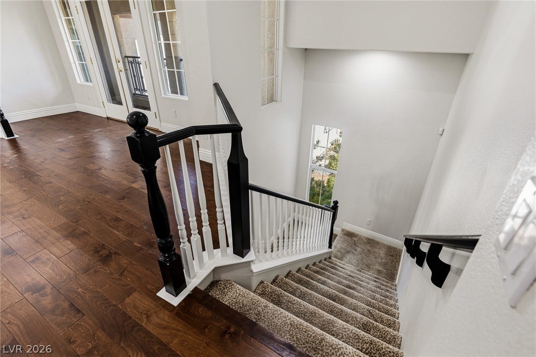 1201 Mersault Court, Las Vegas, NV 89144 Rich hardwood transitions to a carpeted staircase framed by a timeless banister.
