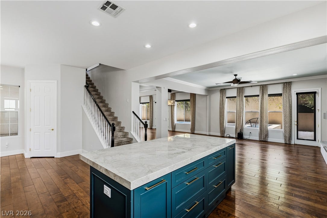 1201 Mersault Court, Las Vegas, NV 89144 Rich wood floors sweep through an open layout connecting the kitchen and living spaces.