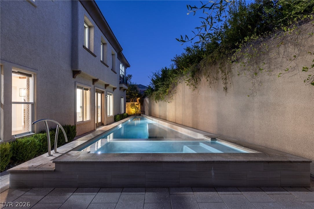 1201 Mersault Court, Las Vegas, NV 89144 An integrated spa and lap pool run parallel to the stucco exterior.