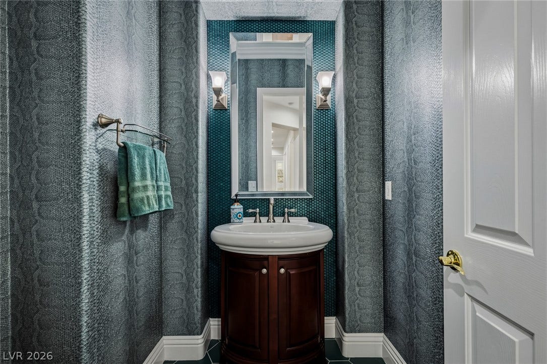 1201 Mersault Court, Las Vegas, NV 89144 Powder Room. Richly textured wall coverings and a tiled backsplash elevate this elegant powder room.