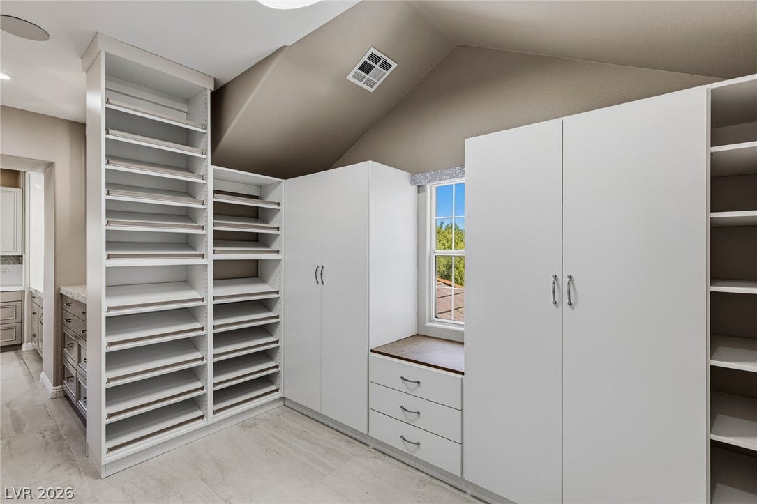 1201 Mersault Court, Las Vegas, NV 89144 Sloped ceilings rise above tailored built-in wardrobe systems and clean tiled flooring.