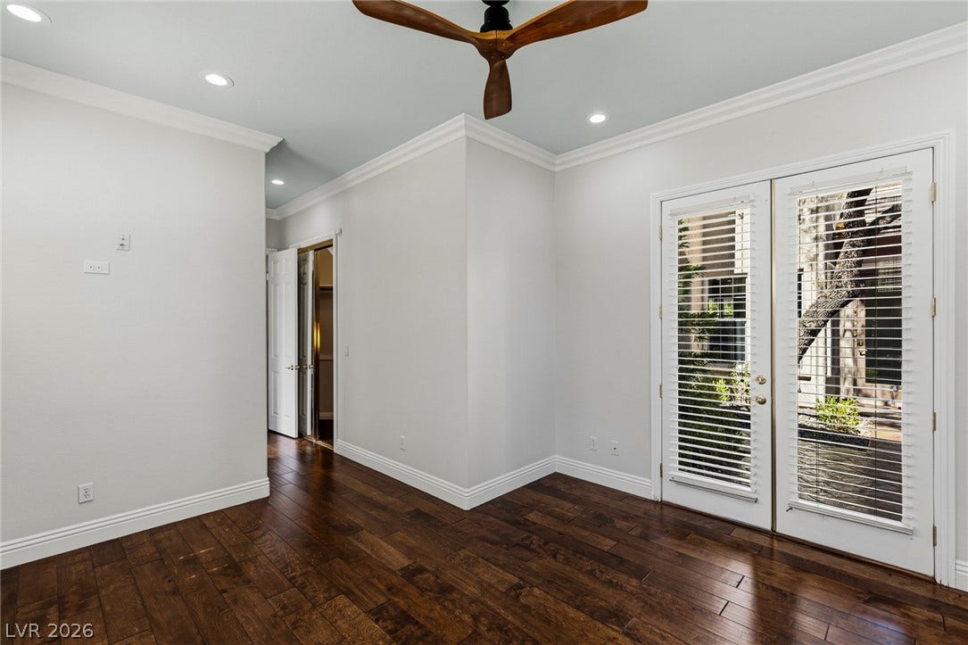 1201 Mersault Court, Las Vegas, NV 89144 Rich hardwood floors contrast beautifully with crisp crown molding and glass-paneled patio doors.