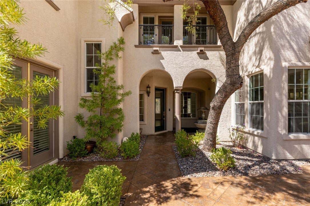 1201 Mersault Court, Las Vegas, NV 89144 Elegant arched entryways and a stamped concrete path create a welcoming courtyard ambiance.