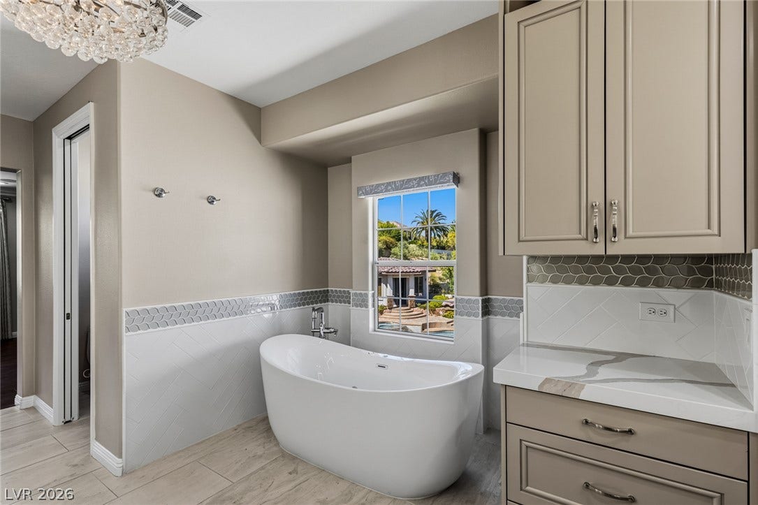 1201 Mersault Court, Las Vegas, NV 89144 A deep soaking tub rests beneath a window overlooking the private yard.
