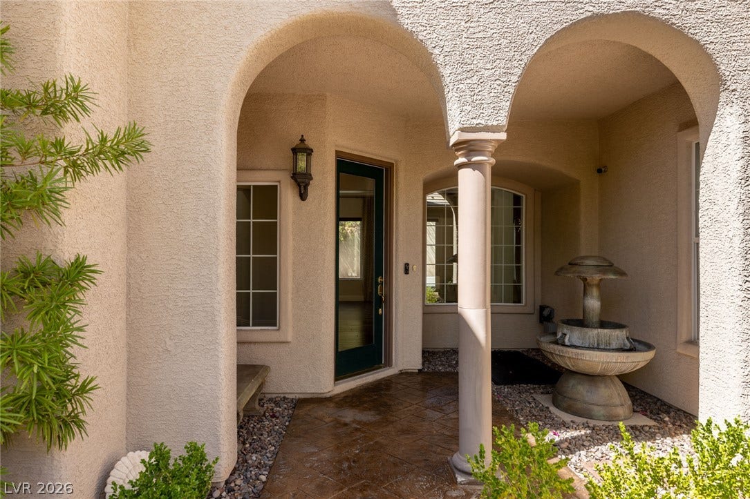 1201 Mersault Court, Las Vegas, NV 89144 Elegant arched entryways frame the stucco exterior and concrete tile walkway leading to the front door.