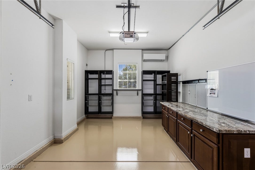 1201 Mersault Court, Las Vegas, NV 89144 Polished epoxy flooring and built-in cabinetry define this functional workspace setup.